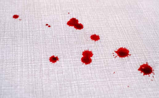Blood drops on grey fabric