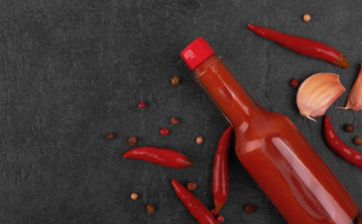 Bottle of hot sauce on grey background