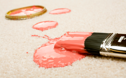 Paint brush with pink paint on carpet