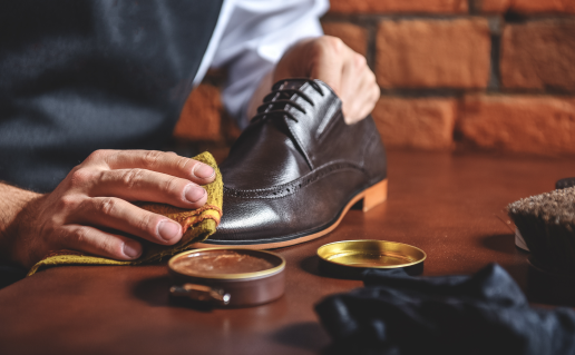 Hands polishing black dress shoes