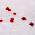 Blood drops on grey fabric